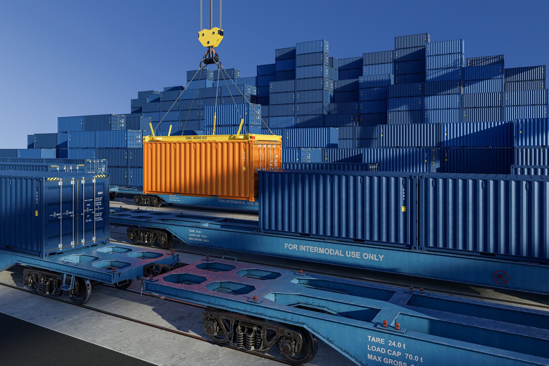 Blue cargo container on railway flatcar at freight terminal